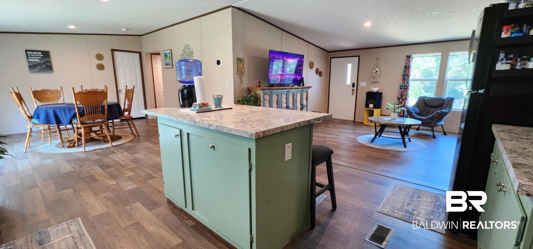 25474 Waterworld Road Robertsdale, AL 36567 - Photo 9 of 30 Kitchen with green cabinets, light countertops, freestanding refrigerator, crown molding, and a kitchen island