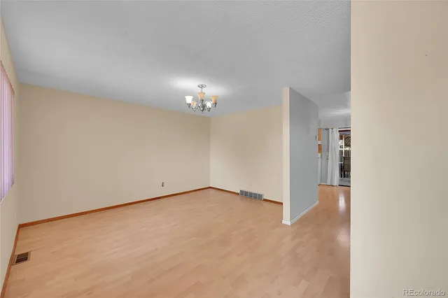 an empty room with chandelier fan