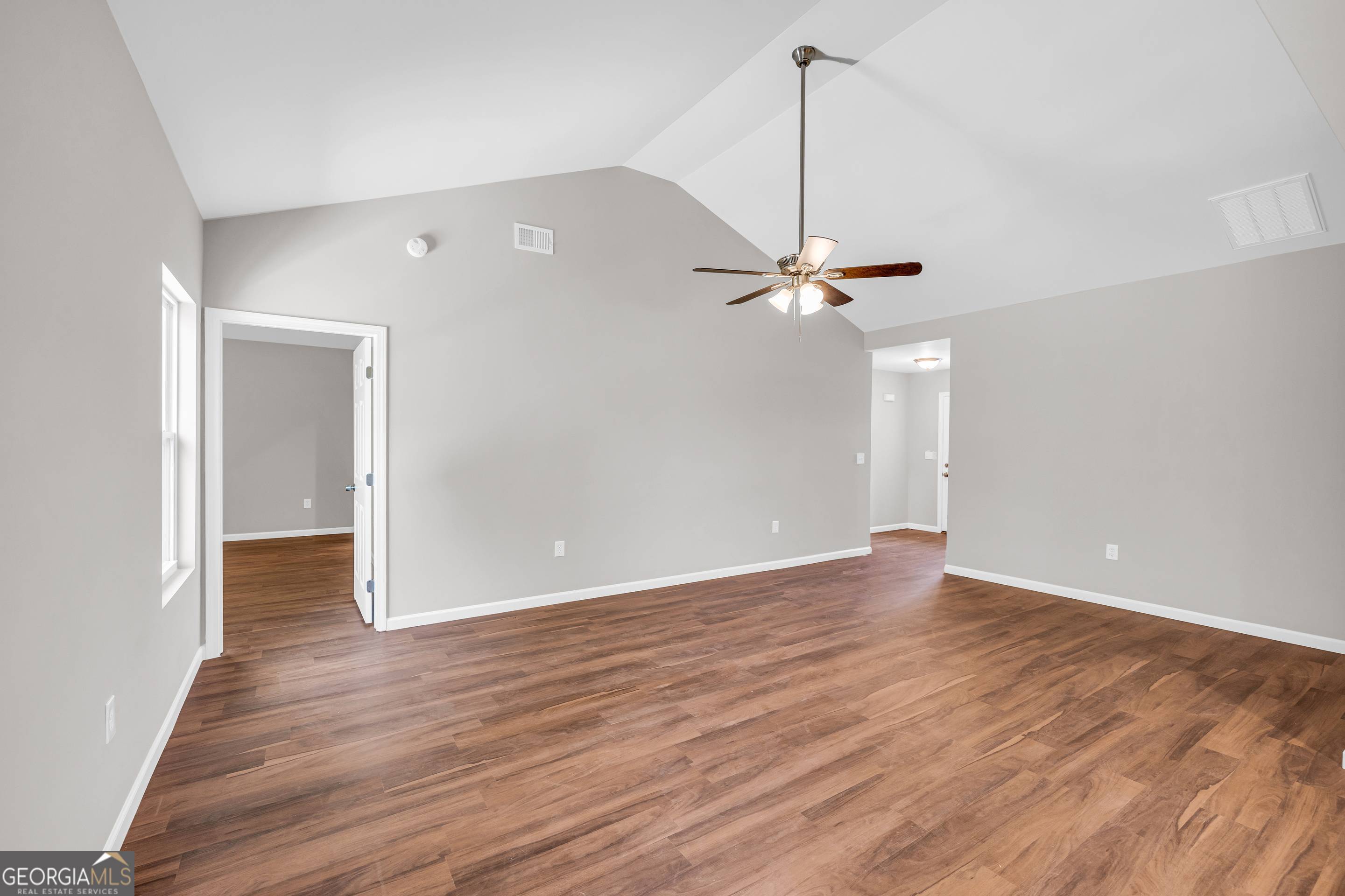 143 ADALINE Court Carnesville, GA 30521 - Photo 13 of 19 a view of a room with wooden floor a ceiling fan and windows