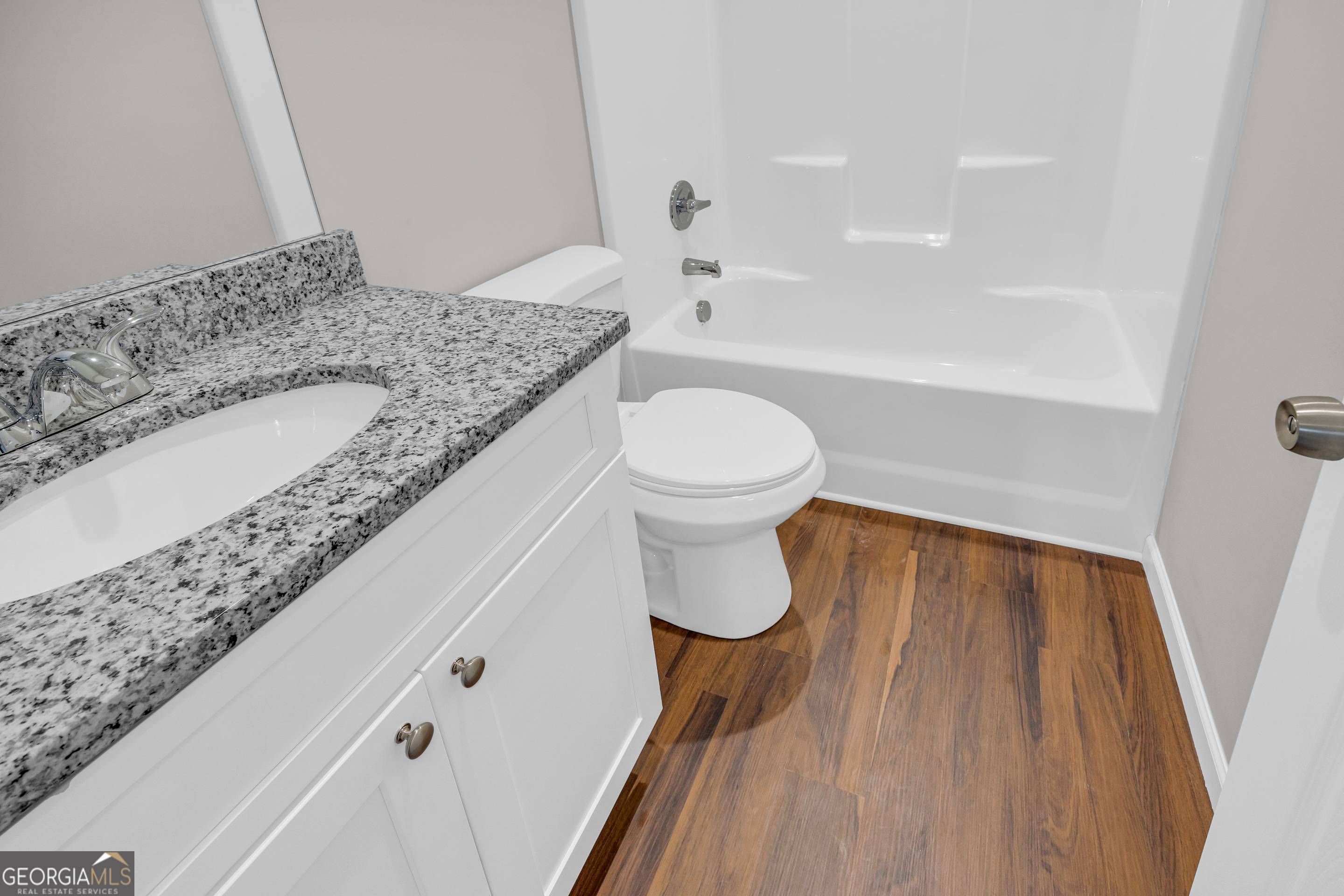 143 ADALINE Court Carnesville, GA 30521 - Photo 6 of 19 a bathroom with a granite countertop sink a toilet and bathtub