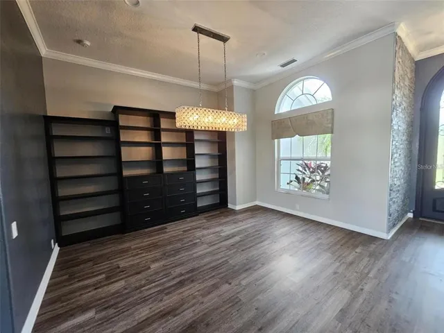 a view of empty room with wooden floor and window