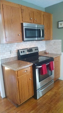 46 Prentice Street Springfield, MA 01104 - Photo 7 of 15 a kitchen with granite countertop a stove and a microwave