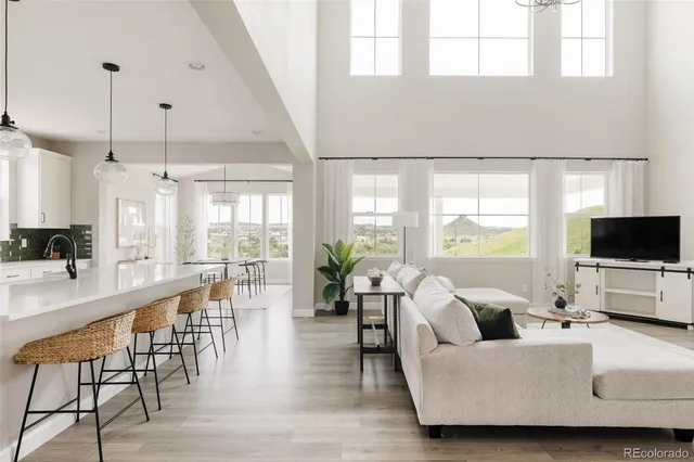 a large white kitchen with lots of counter space dining table and stainless steel appliances