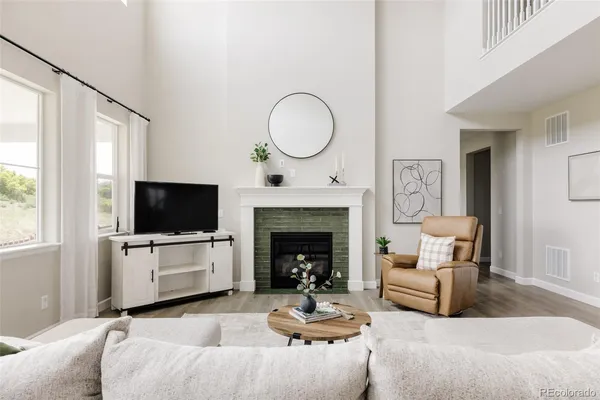 a living room with furniture a flat screen tv and a fireplace