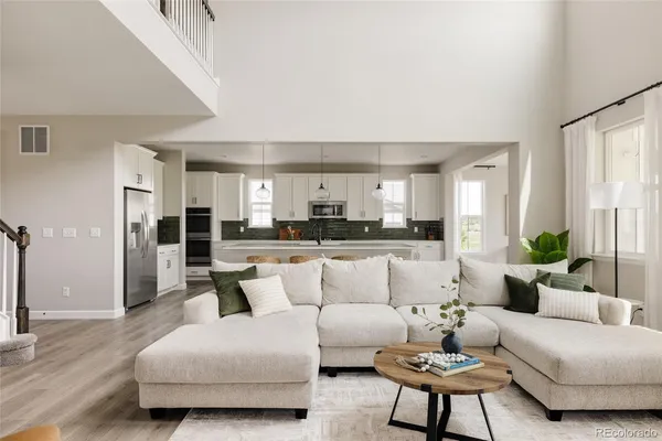 a living room with furniture and a view of kitchen