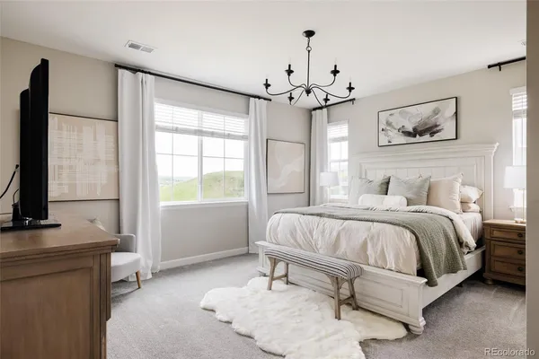 a spacious bedroom with a bed and a flat screen tv