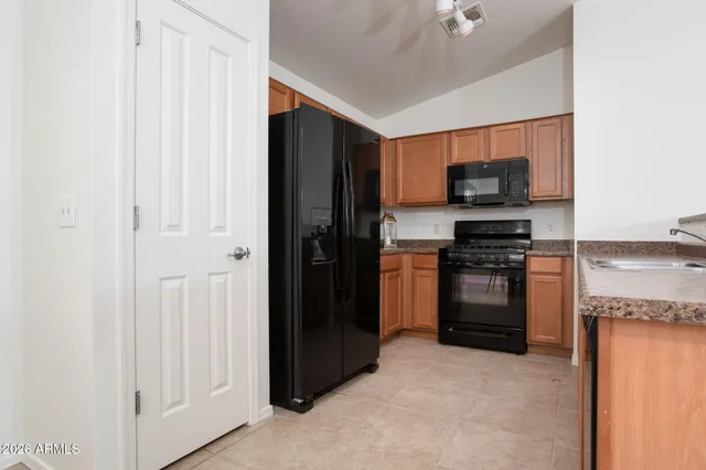 a dining room with chandelier fan and wooden floor