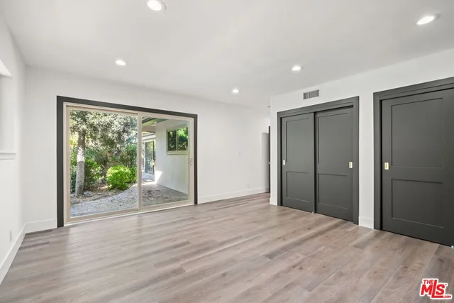 a view of a room with wooden floor and a window