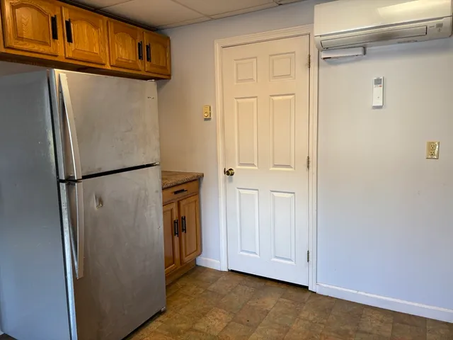 a view of a refrigerator in kitchen with stainless steel appliances wooden cabinet