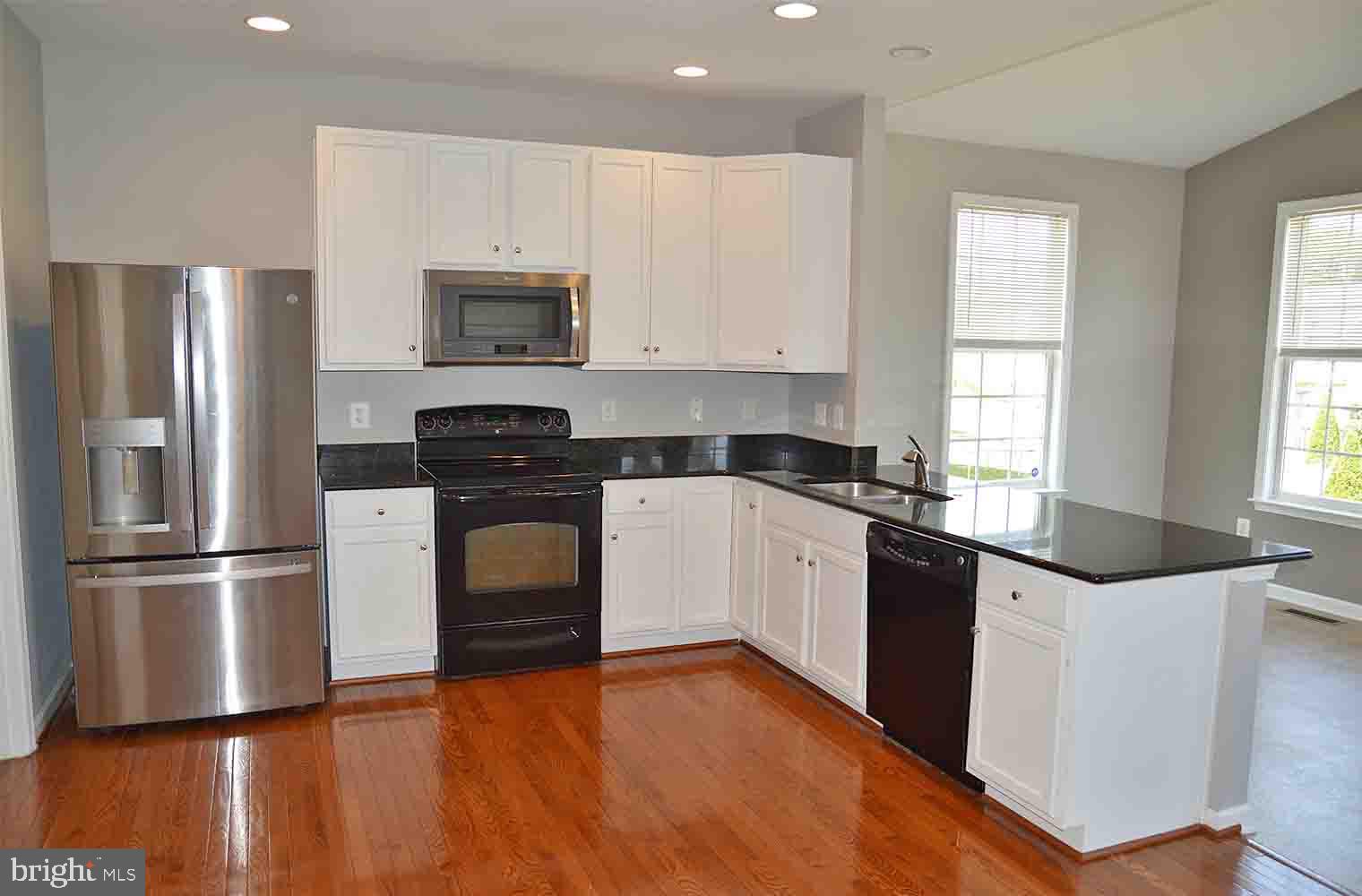 167 Bouldin Road Charles Town, WV 25414 - Photo 4 of 30 a kitchen with granite countertop a refrigerator and a stove top oven