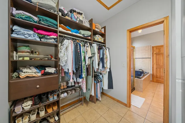 a view of walk in closet with clothes and shoes