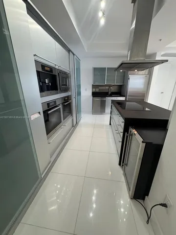 a kitchen with stainless steel appliances a refrigerator and a stove top oven