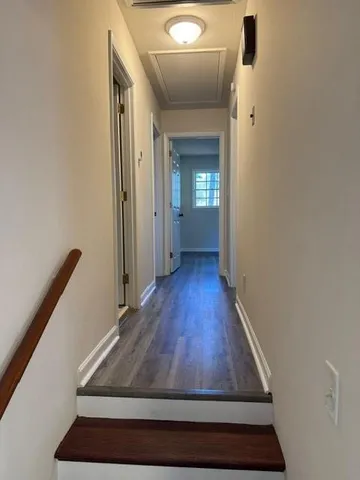 a view of a hallway with wooden floor