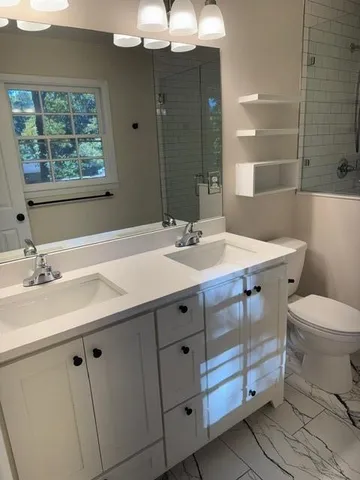 a bathroom with a sink a toilet and a mirror