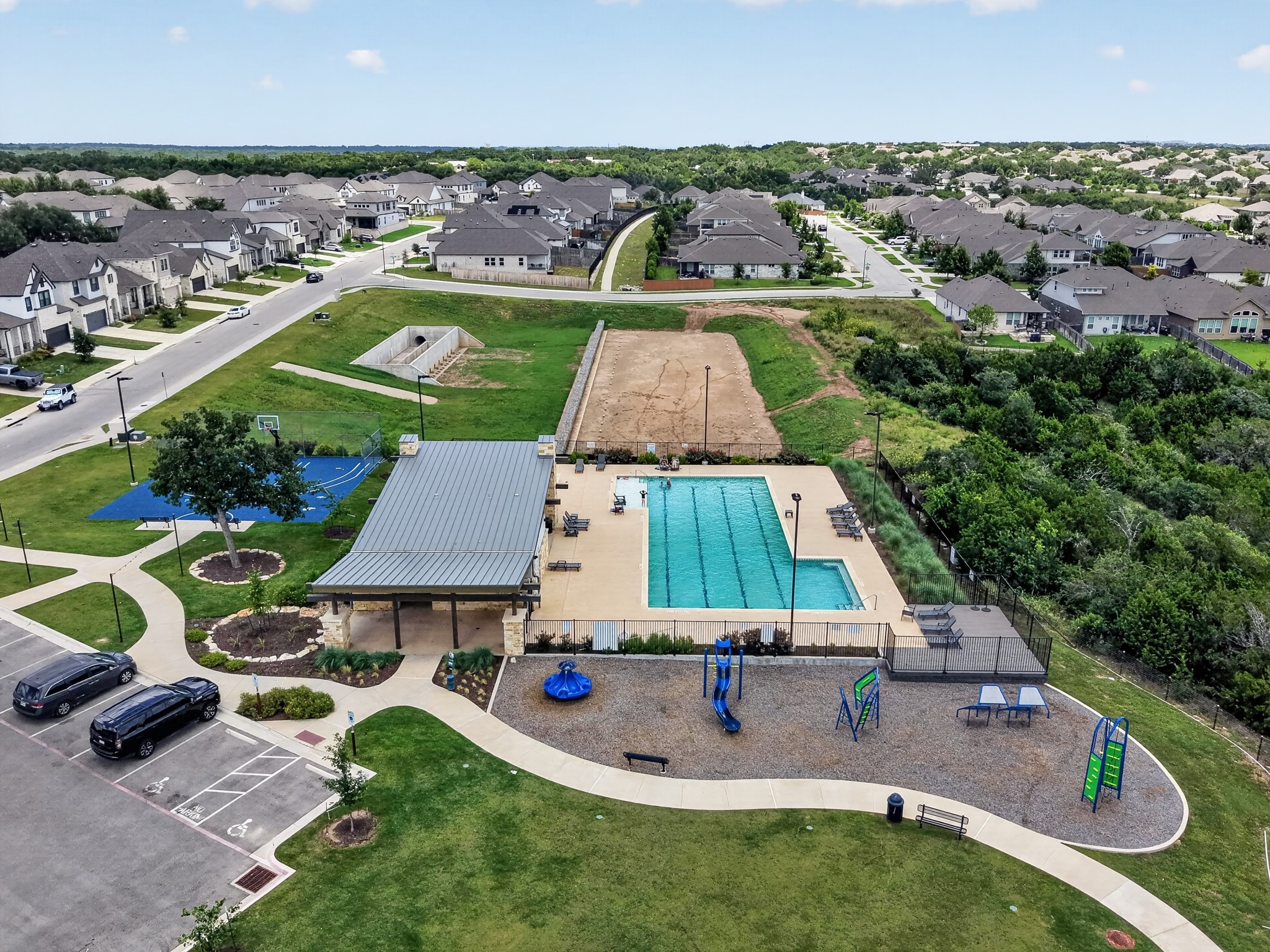 508 Pinnacle View Drive Georgetown, TX 78628 - Photo 27 of 27 Aerial view showcasing a lively community pool and recreational areas, nestled within a thriving neighborhood.