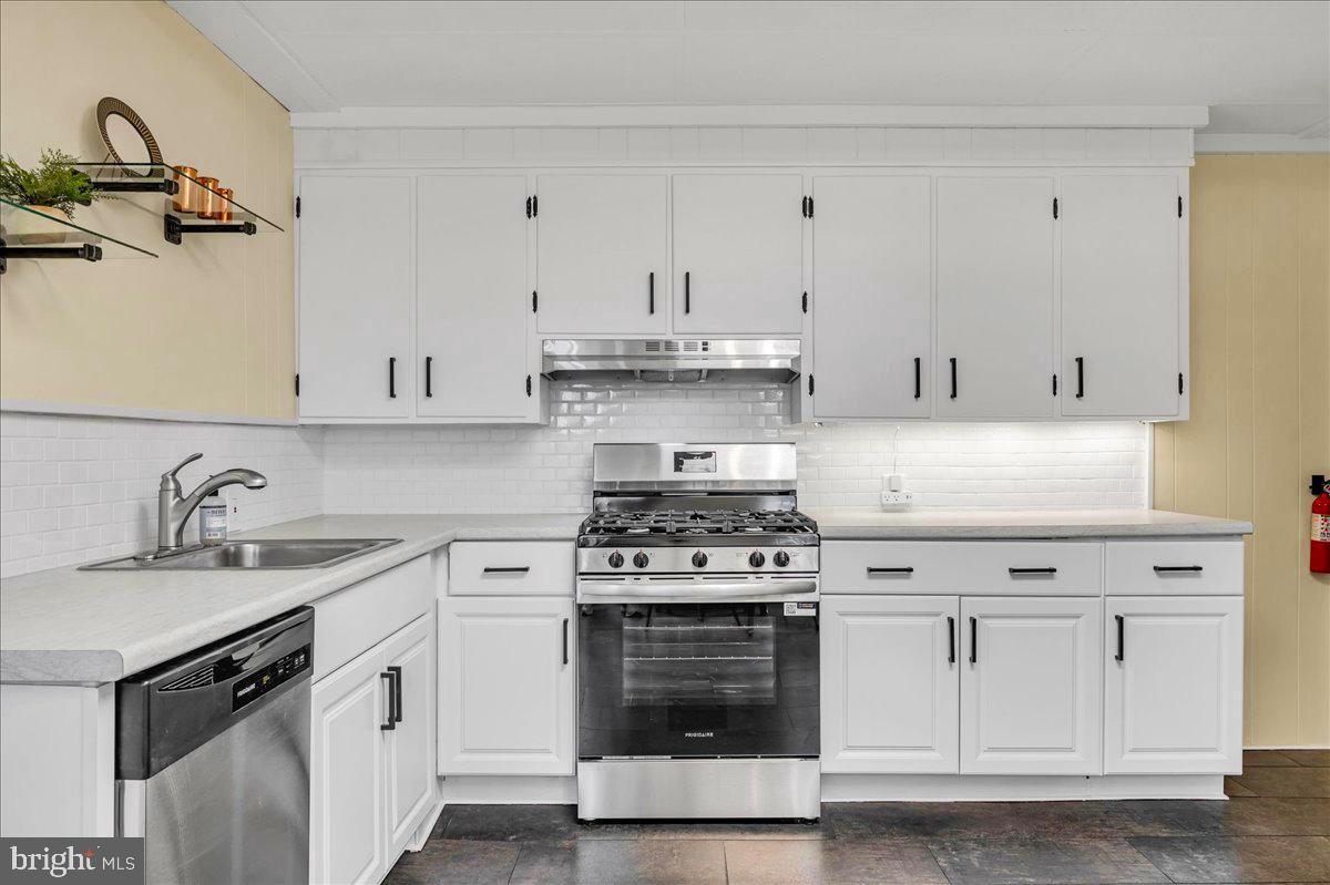 208 8th Street Brookhaven, PA 19015 - Photo 11 of 31 a white kitchen with granite countertop white cabinets and stainless steel appliances