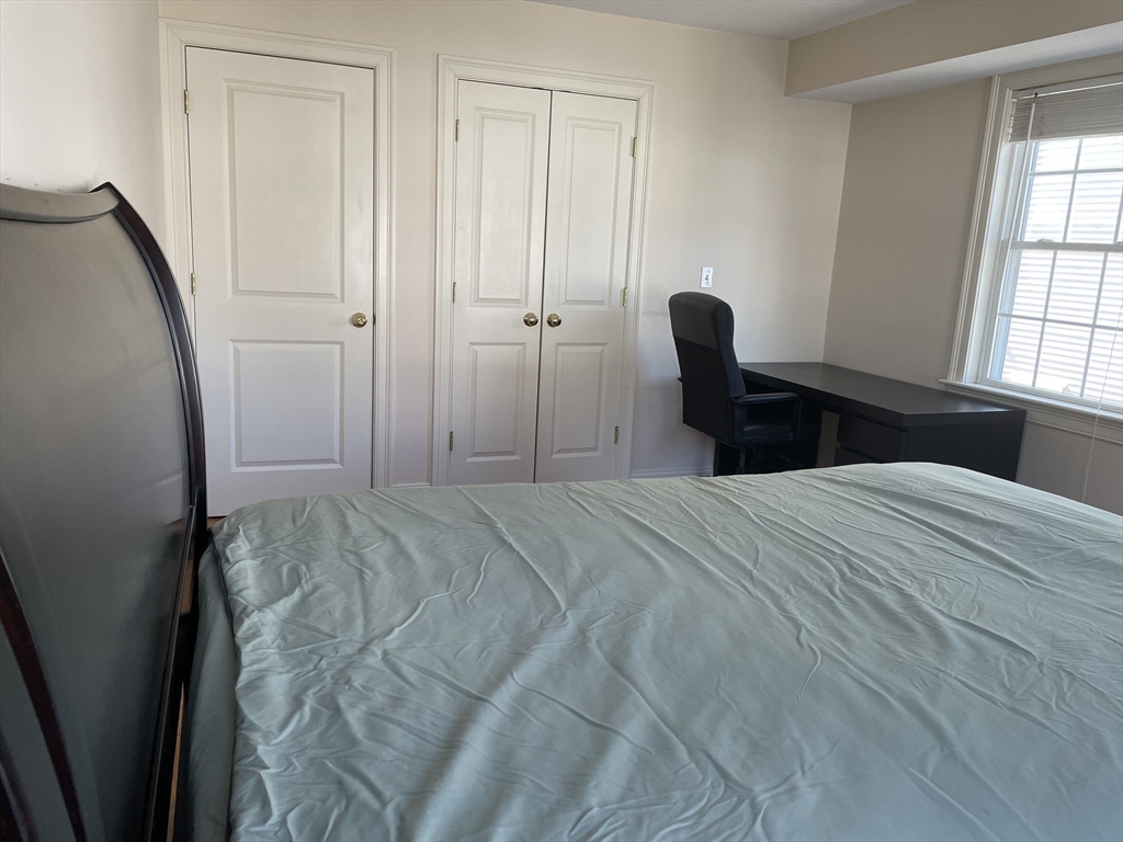 220 Grove Street, Unit 1 Waltham, MA 02453 - Photo 16 of 34 a bedroom with a bed and a window