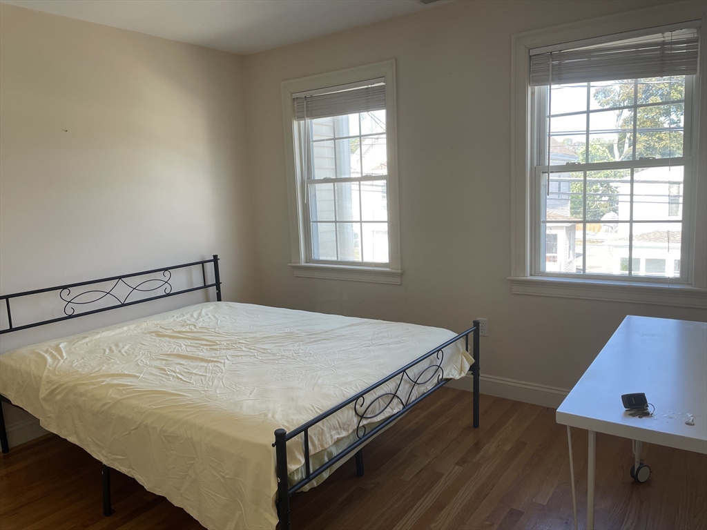 220 Grove Street, Unit 1 Waltham, MA 02453 - Photo 26 of 34 a bed sitting in a bedroom next to a window