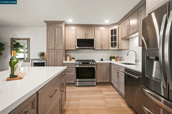 a kitchen with stainless steel appliances granite countertop a stove refrigerator and a sink