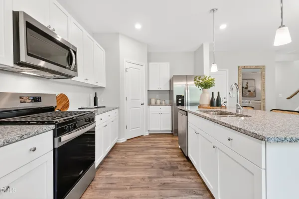 a kitchen with stainless steel appliances granite countertop a stove a sink and a microwave