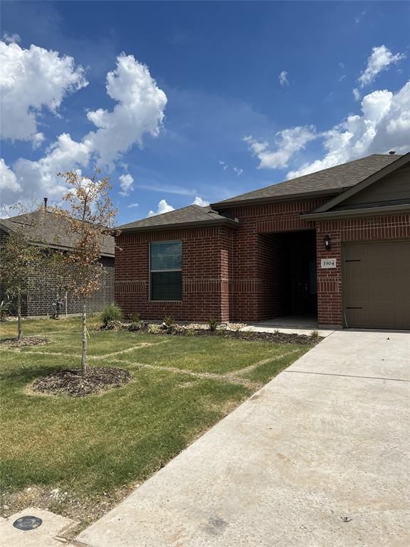 a front view of a house with a yard and a garage