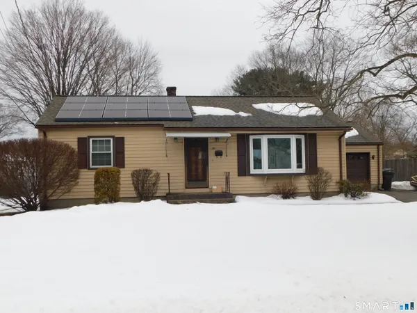 a front view of house with yard covered in snow