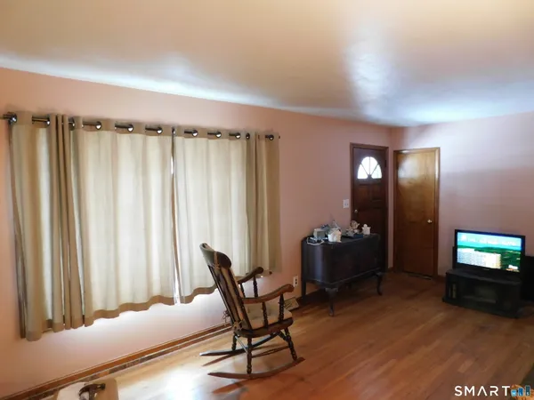 a living room with furniture a flat screen tv and a window