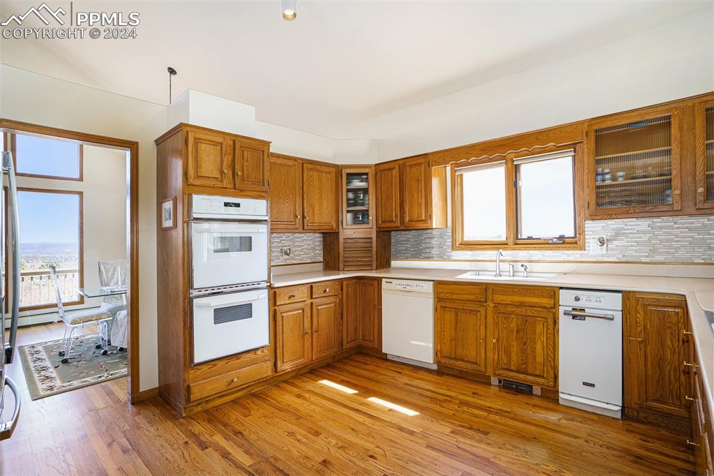 4315 Star Ranch Road Colorado Springs, CO 80906 - Photo 11 of 47 a kitchen with stainless steel appliances granite countertop a refrigerator a stove and white cabinets with wooden floors