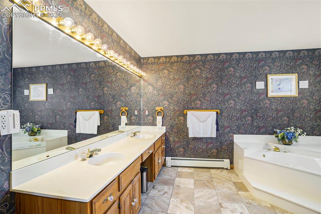 4315 Star Ranch Road Colorado Springs, CO 80906 - Photo 18 of 47 a spacious bathroom with a tub sink and mirror