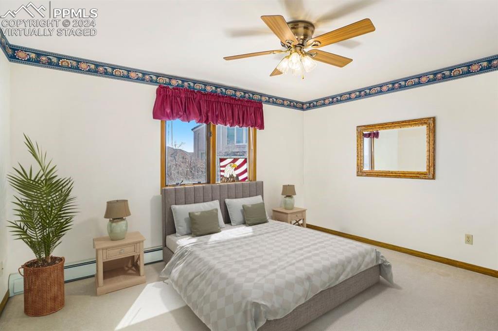 4315 Star Ranch Road Colorado Springs, CO 80906 - Photo 27 of 47 a bedroom with a bed and a chandelier