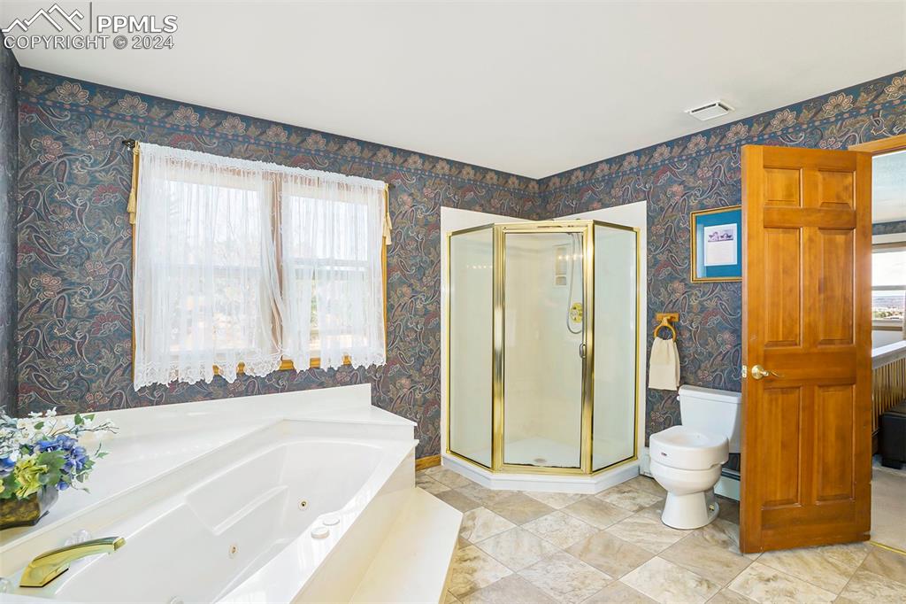 4315 Star Ranch Road Colorado Springs, CO 80906 - Photo 5 of 47 a spacious bathroom with a granite countertop toilet and a bathtub