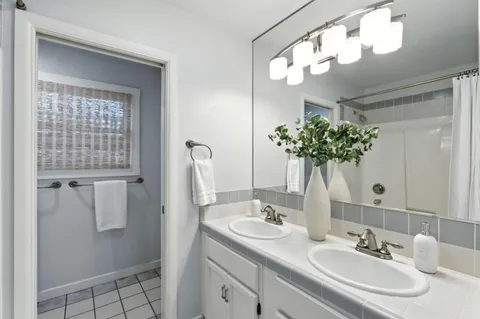 a bathroom with a sink a light fixture and a mirror