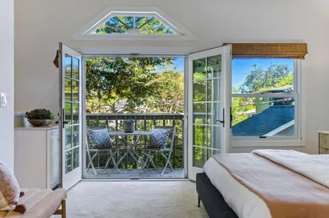 a bedroom with a bed and a large window