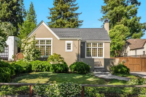 a view of a house with a yard and potted plants