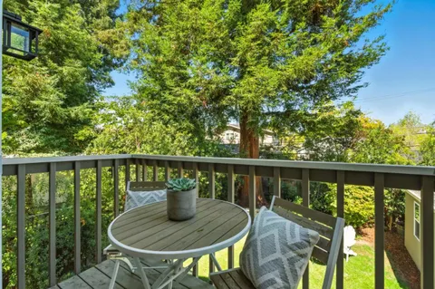 a balcony with wooden floor table and chairs