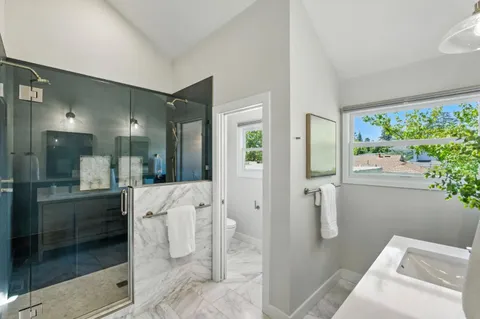 a bathroom with a double vanity sink toilet and shower