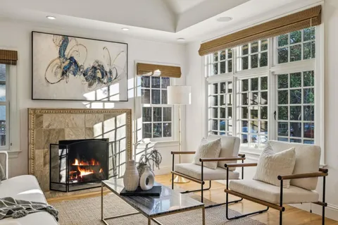 a living room with furniture a fireplace and a large window