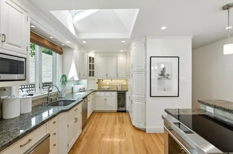 a large kitchen with granite countertop a large counter top appliances a sink and a counter top space