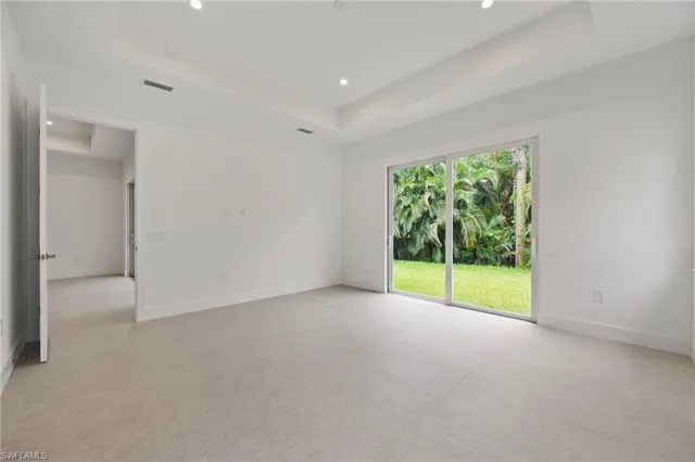 a view of an empty room with large windows and garden view