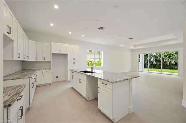 a kitchen with granite countertop a sink and cabinets