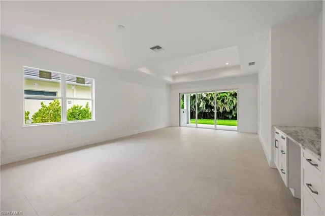 a view of an empty room with a window and a ceiling fan