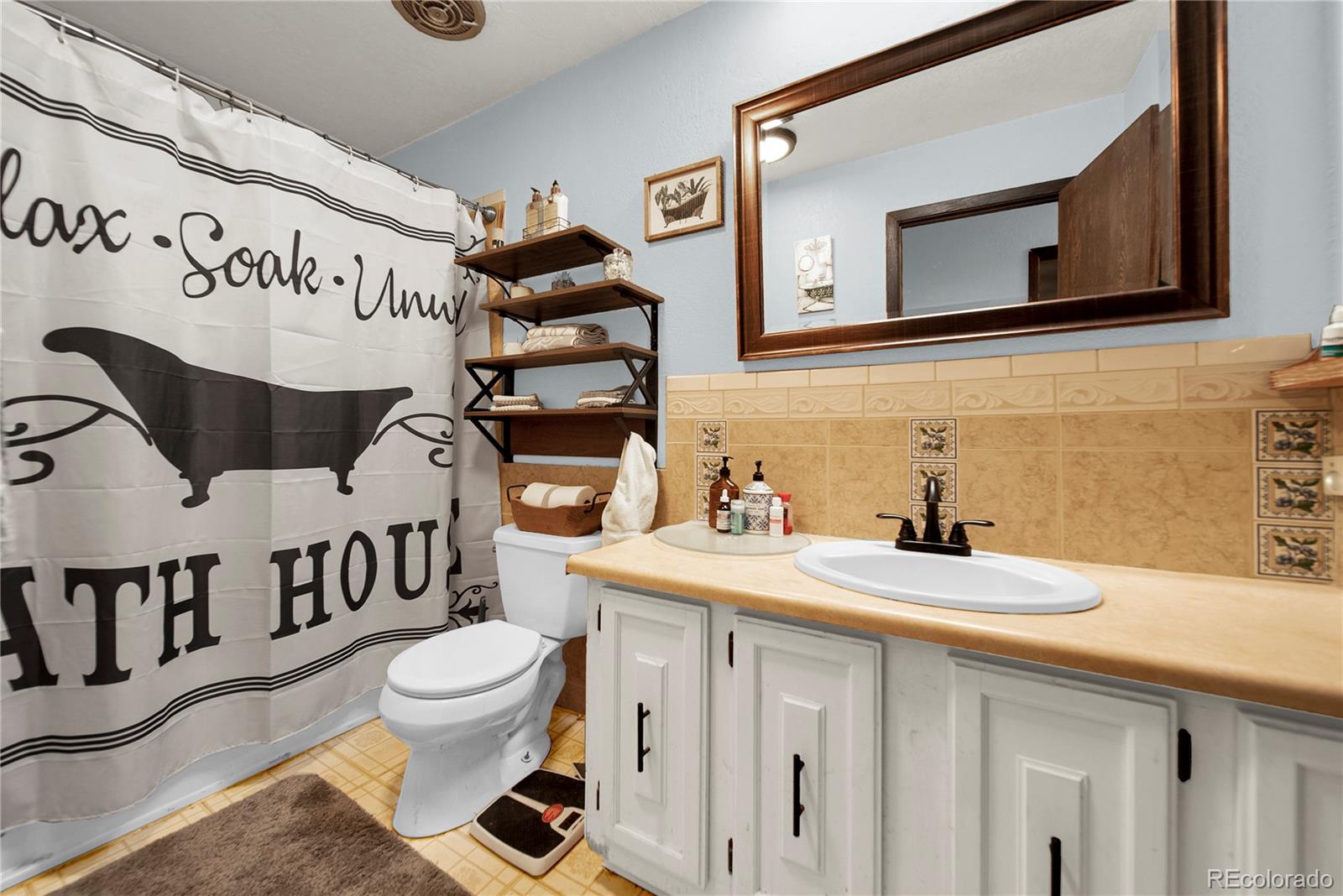 404 Hickory Street Fort Morgan, CO 80701 - Photo 19 of 37 a bathroom with a sink a toilet and a mirror