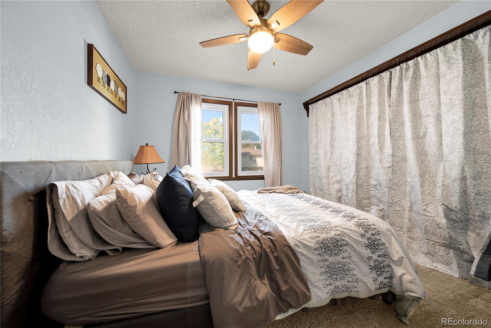 404 Hickory Street Fort Morgan, CO 80701 - Photo 24 of 37 a bedroom with a bed and a chandelier