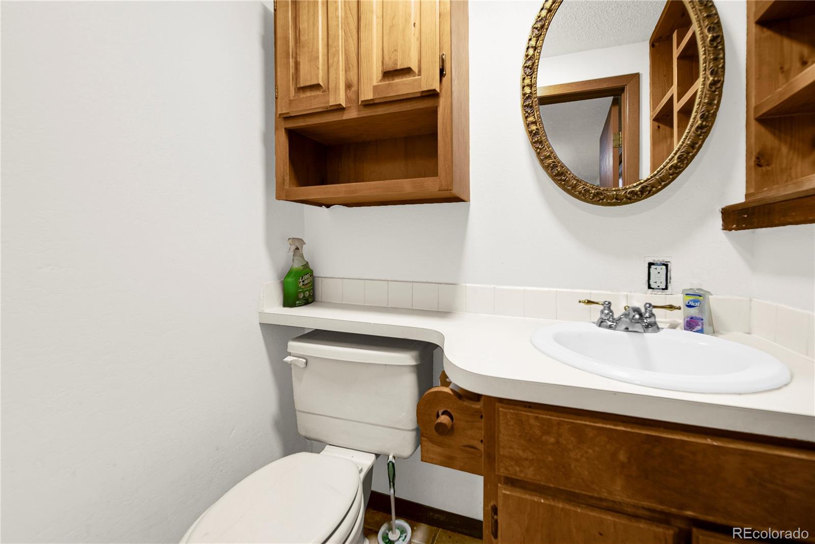 404 Hickory Street Fort Morgan, CO 80701 - Photo 29 of 37 a bathroom with a toilet a sink and mirror
