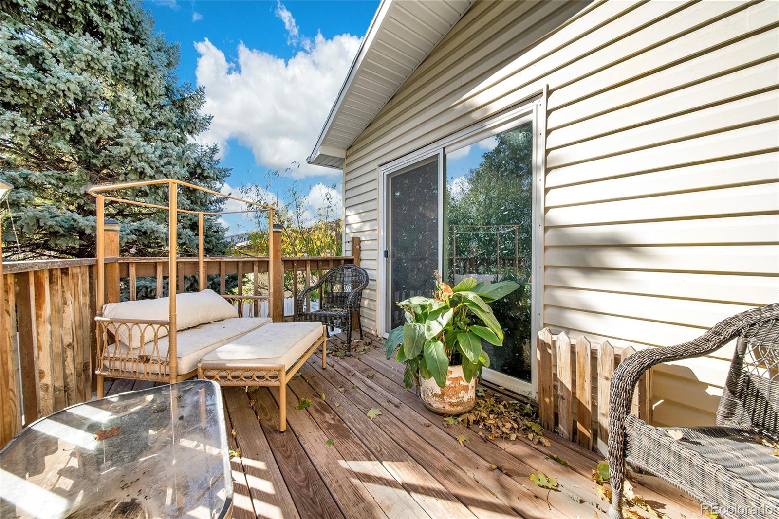 404 Hickory Street Fort Morgan, CO 80701 - Photo 34 of 37 a view of a patio with table and chairs potted plants with wooden floor and fence