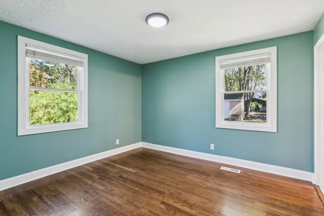 a bathroom with a double vanity sink and mirror with window