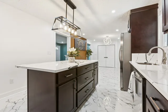 a kitchen with stainless steel appliances granite countertop a sink a stove and cabinets