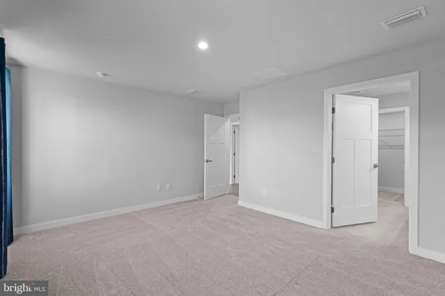 a view of an empty room with glass door and a window