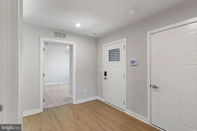 an empty room with wooden floor & closet area