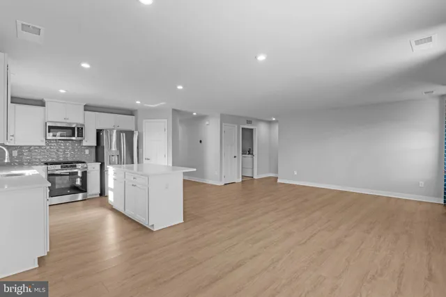 a view of kitchen with kitchen island and stainless steel appliances